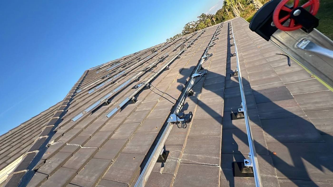 Bare solar mounting rails left on a tile roof after the panels were taken off